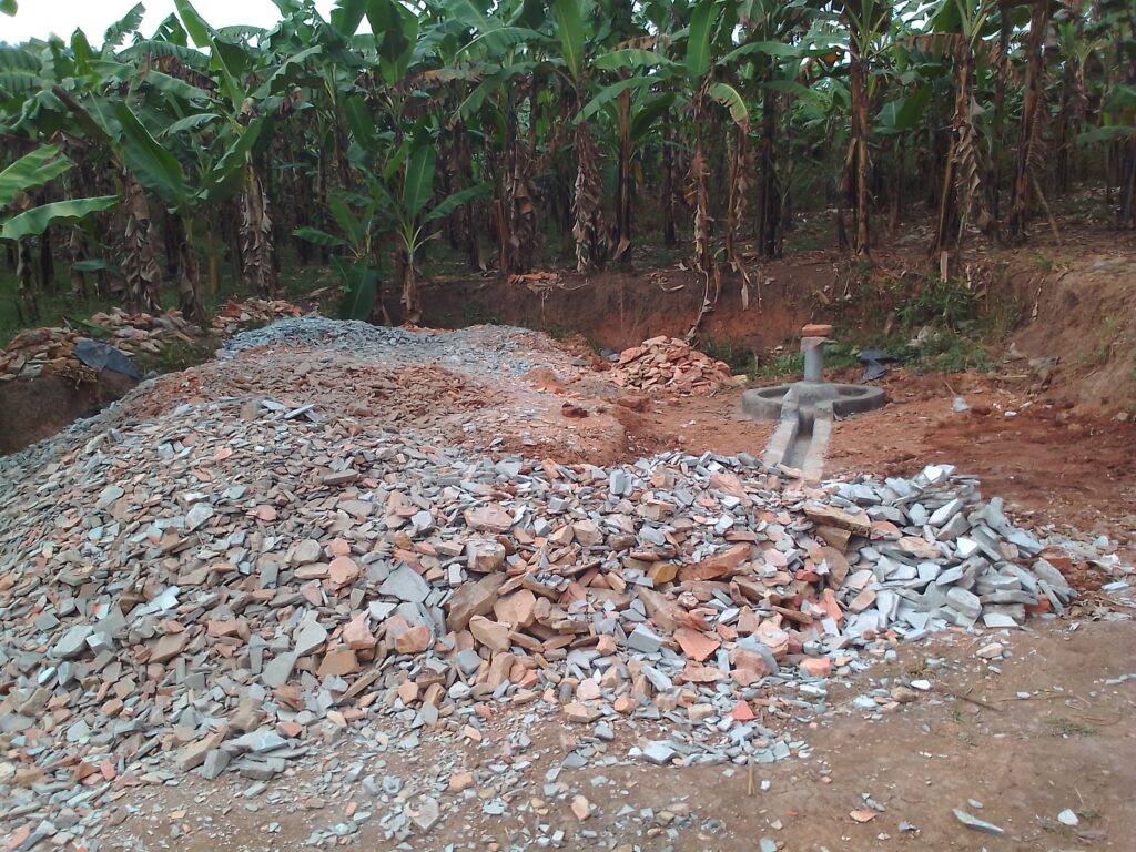 Well site with well head and stone from digging the well shaft.