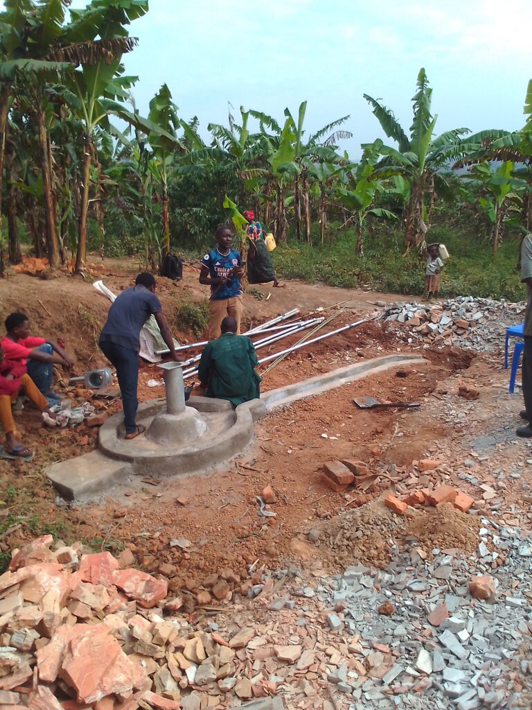 Men assembling pipes for well shaft.