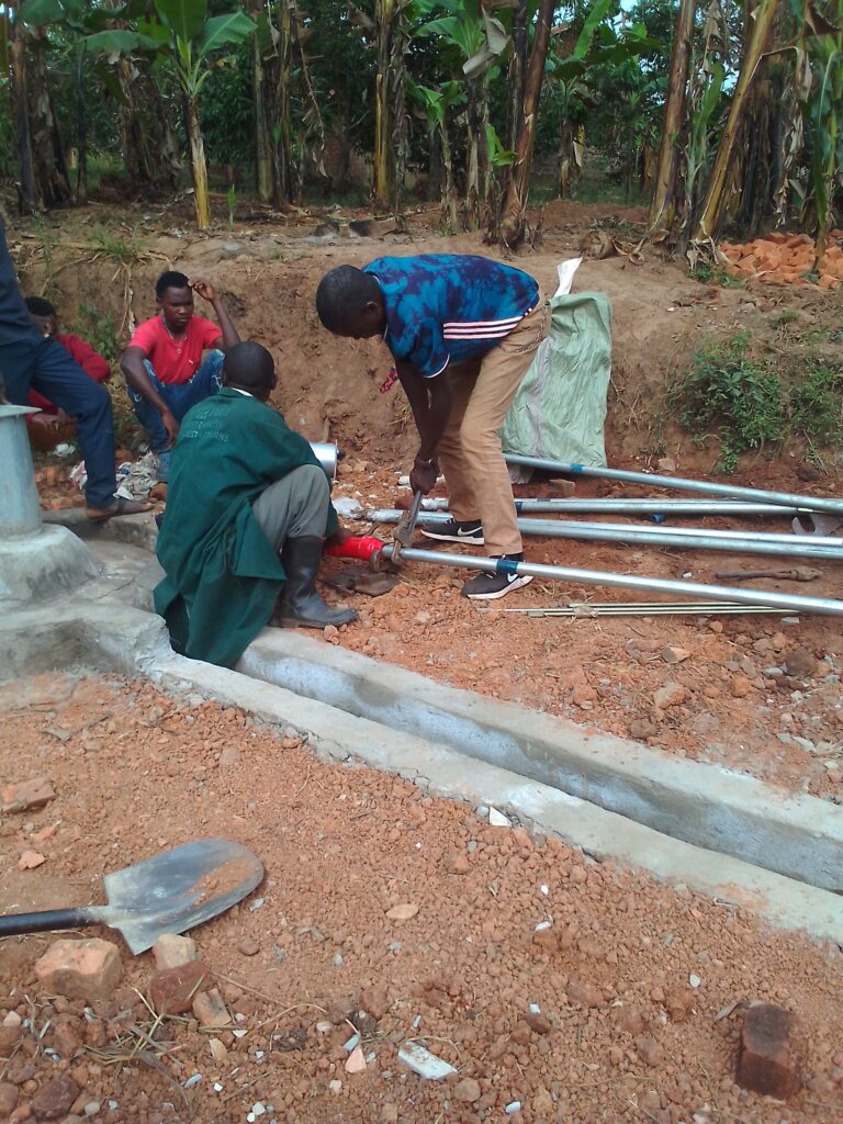 Men assembling pipes for well