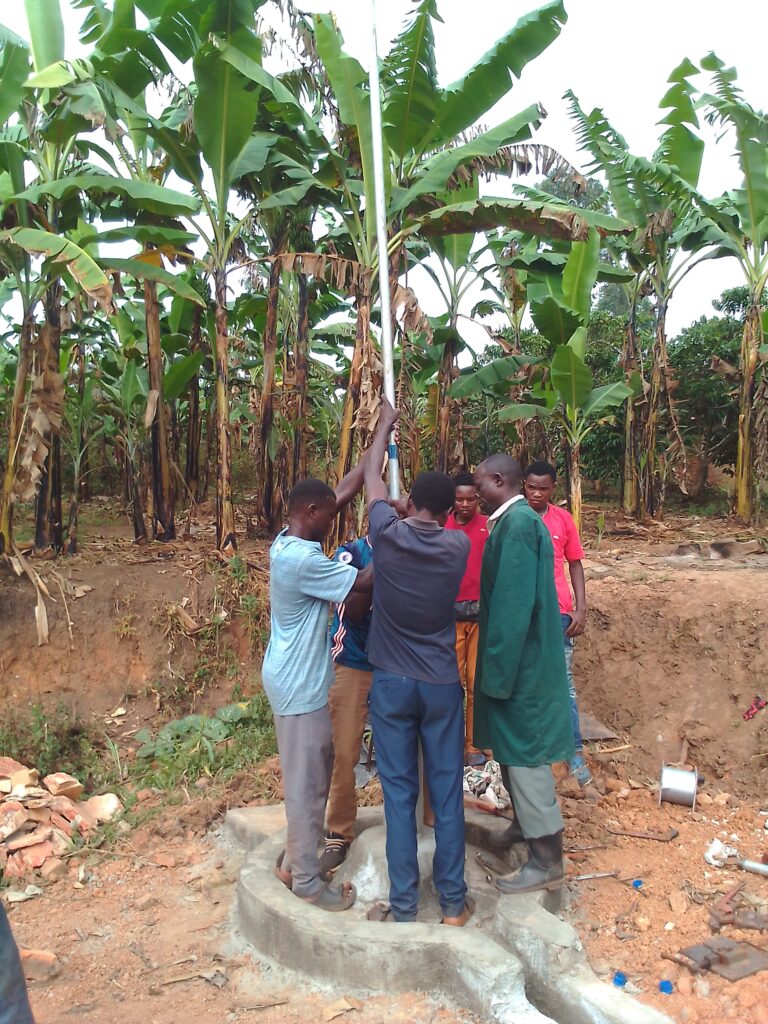 Men inserting pipes into the well shaft