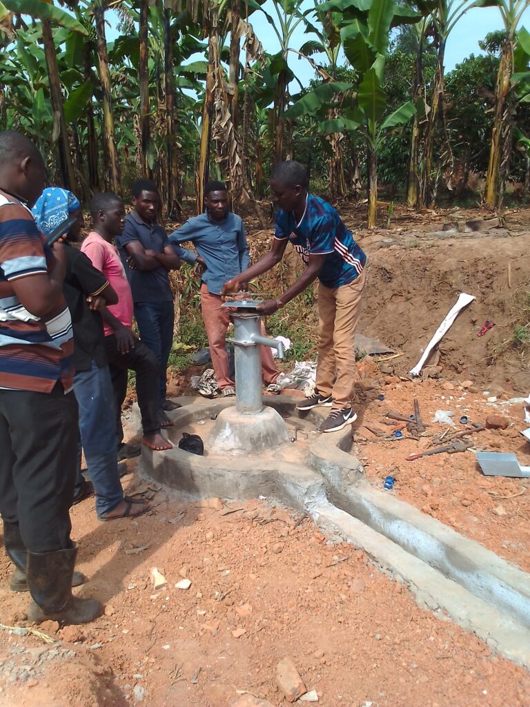 Men completing the well pump.